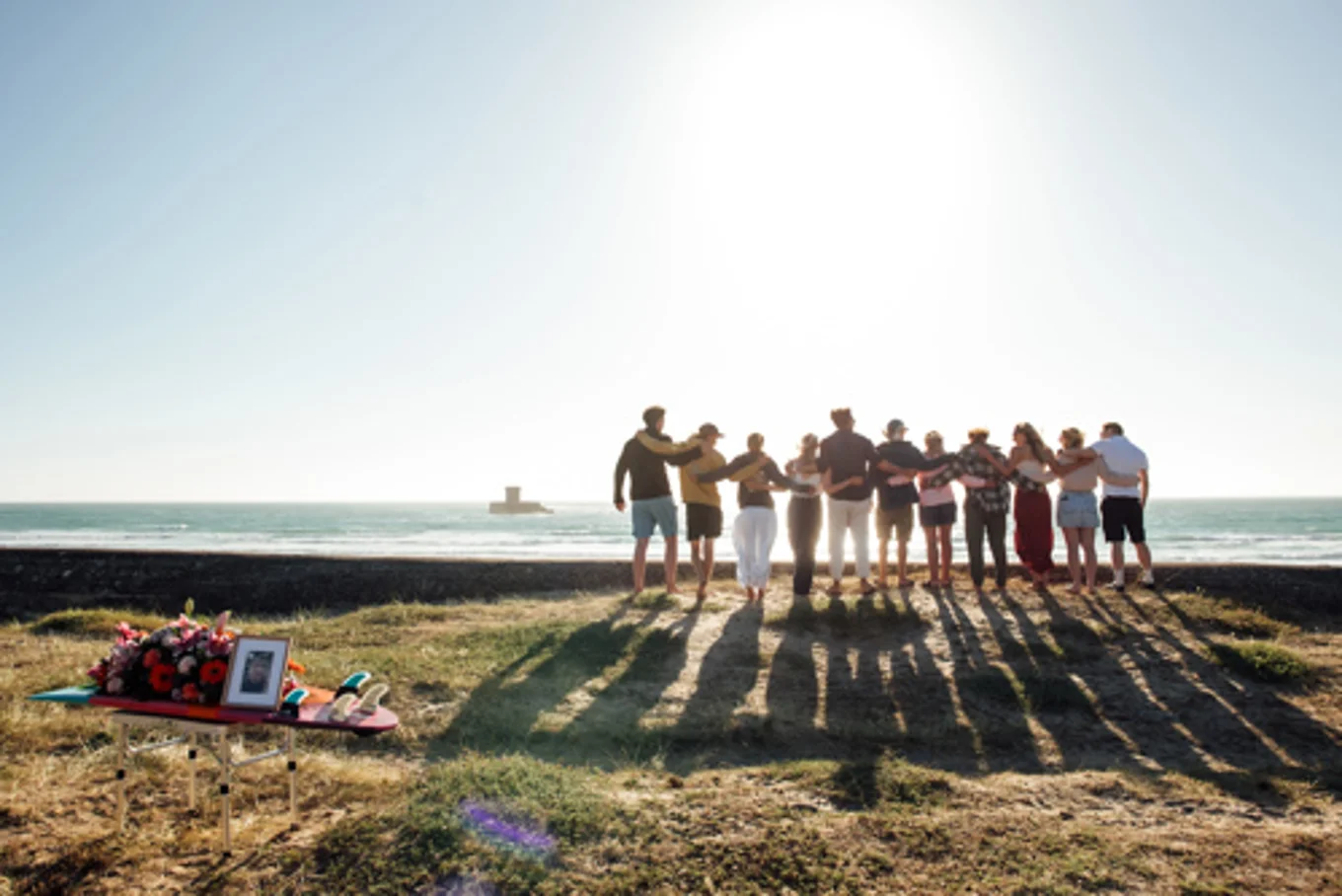 Family and friends gather by the sea to remember a loved one.