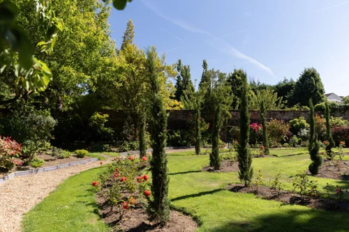 Tranquil memorial garden with landscaped grounds, trees and seasonal flowers in Guernsey.