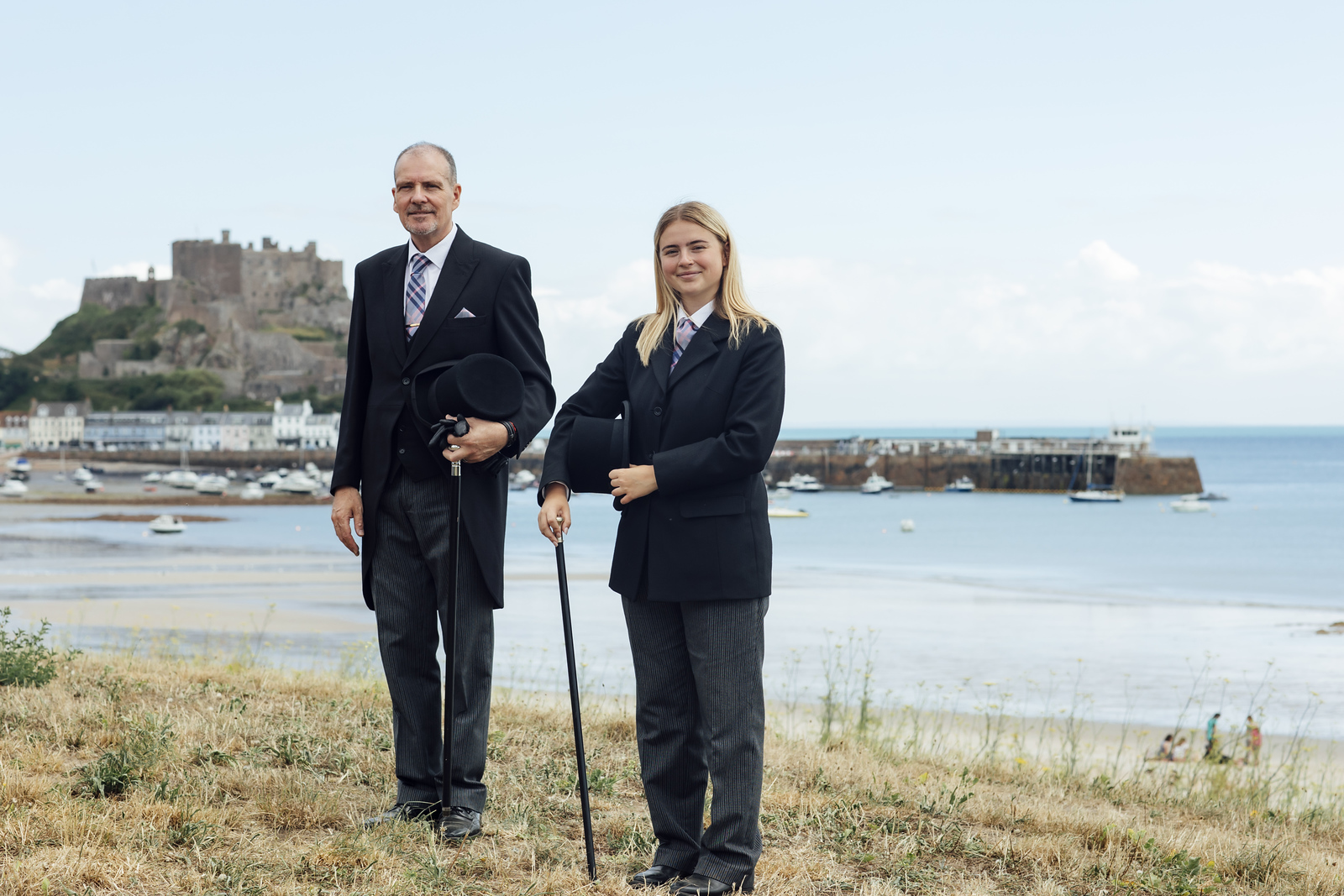 Funeral Directors Standing next to each other with Gorey Castle and harbour in the background.