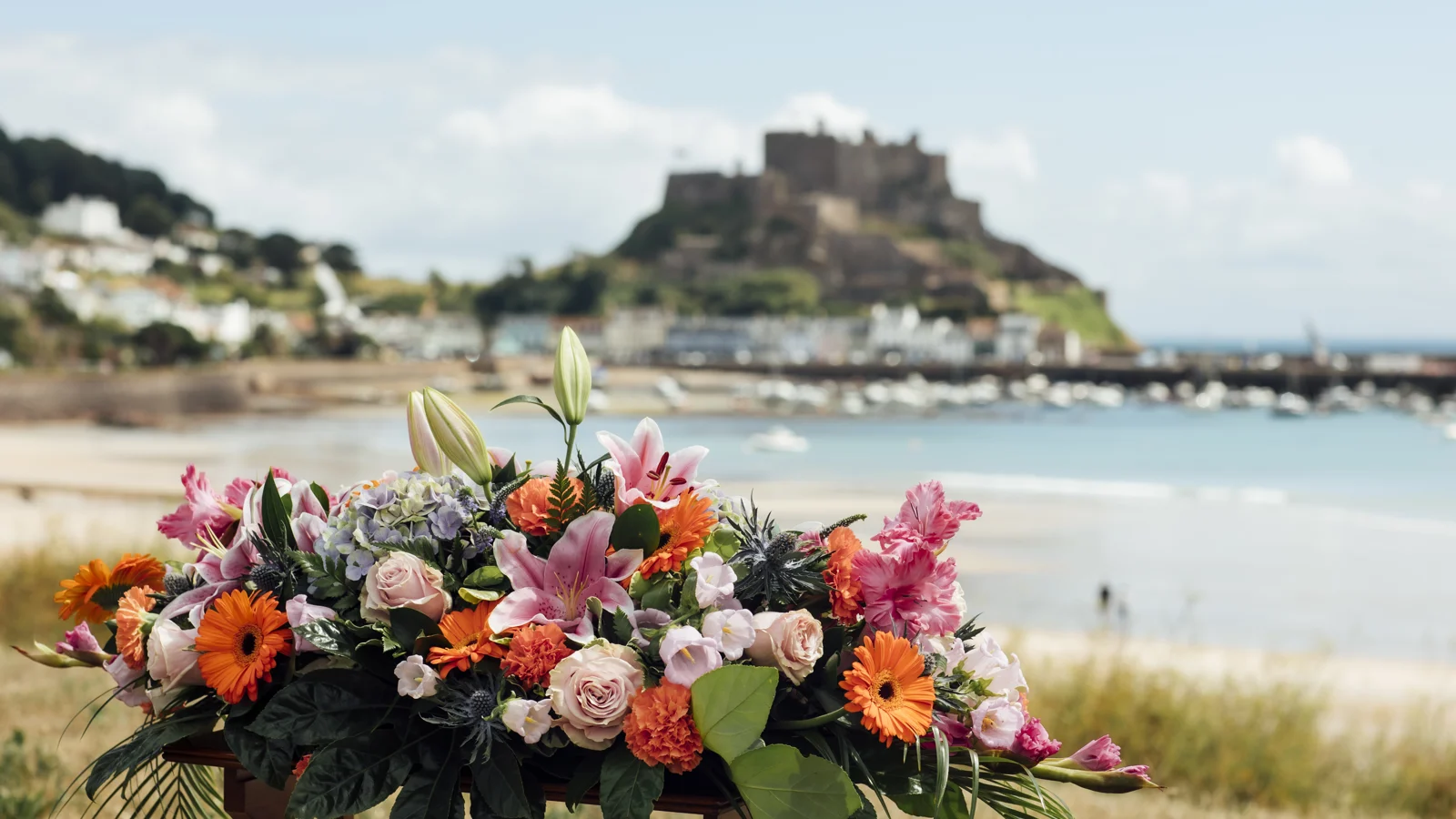 Colourful funeral flower arrangement overlooking Gorey Castle and harbour.