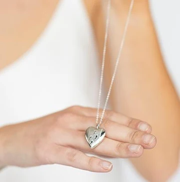 Heart-shaped memorial keepsake pendant on a chain, symbolising remembrance of a loved one.